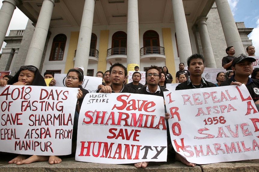 Protesters hold placards during a silent sit-in protest in support of Irom Sharmila