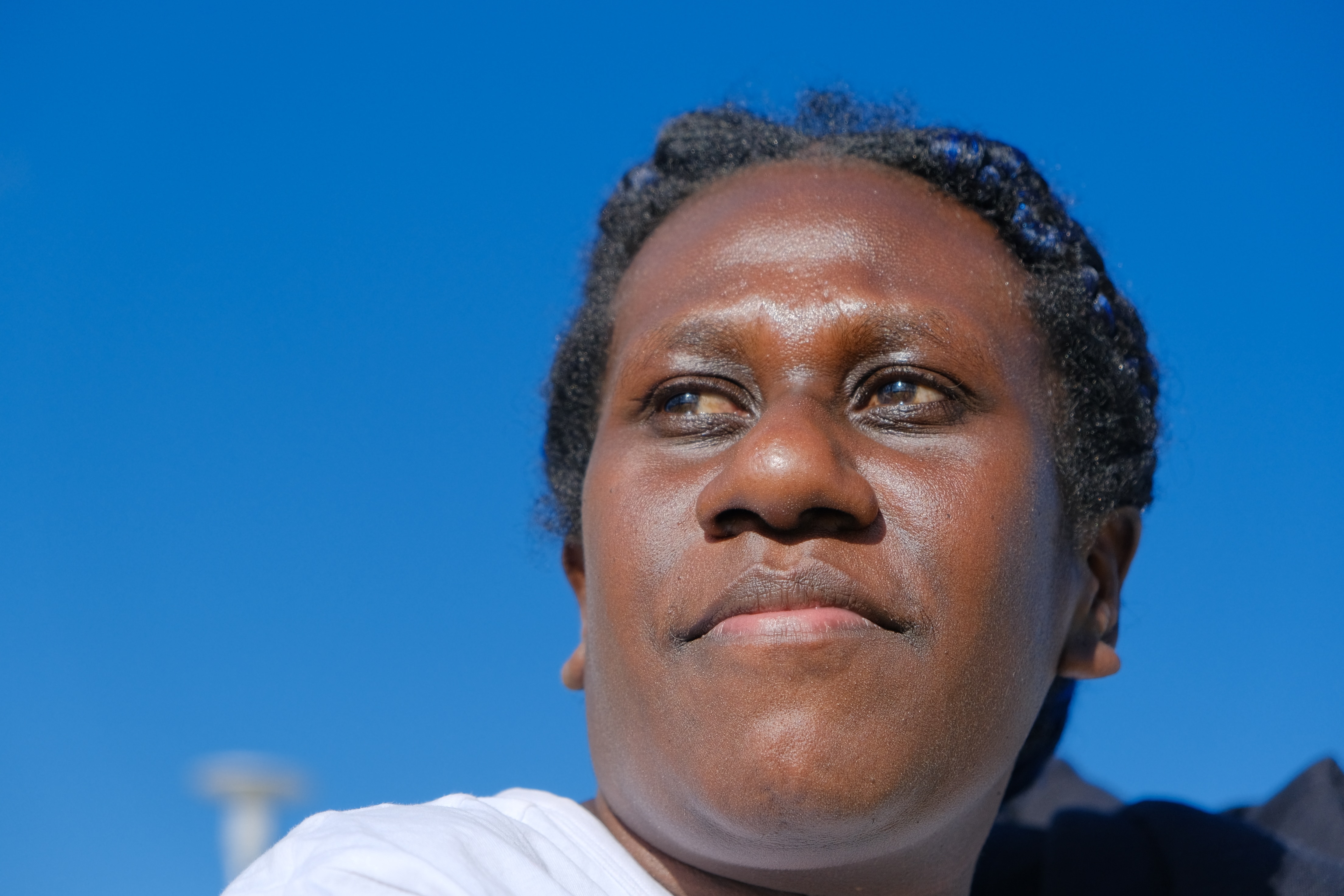 Female Pacific Islander looks into the camera against the backdrop of a blue sky