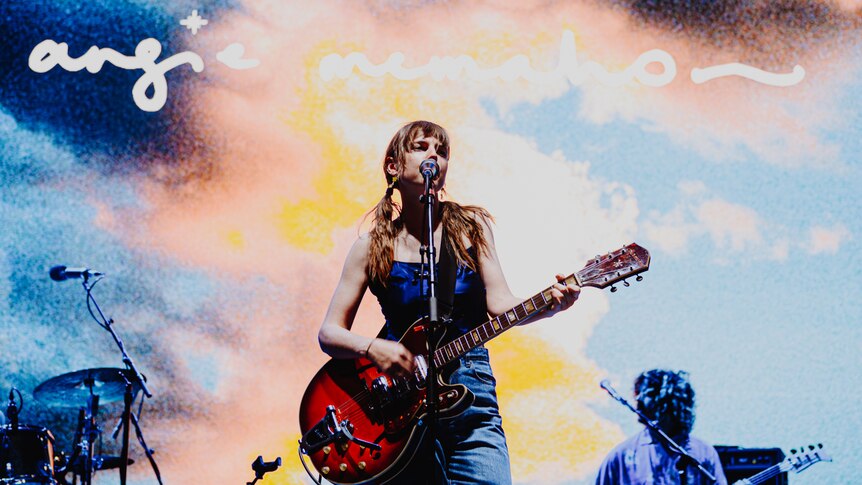 Angie McMahon performs live at Laneway Festival 2024 with a red guitar and under blue lighting