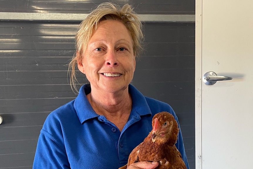 Woman standing holding a chicken