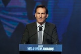An AFL executive speaks at a lectern.