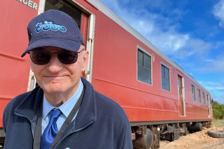 A man in a Steam Ranger cap next to the cockle train.