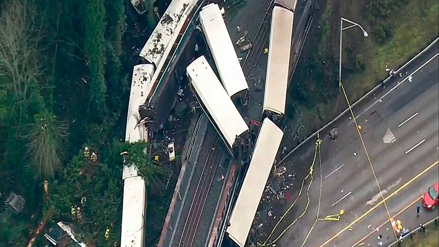 A still from video shows an aerial shot of mangled train carriages.
