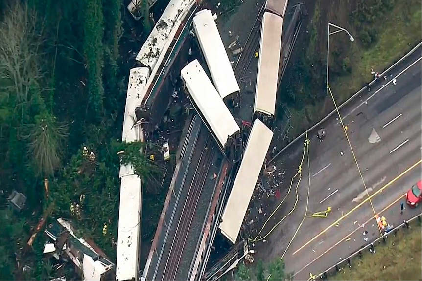 A still from video shows an aerial shot of mangled train carriages.