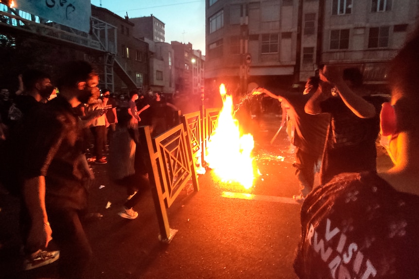 Protesters make fire and block the street during a protest over the death of a woman who was detained by the morality police.