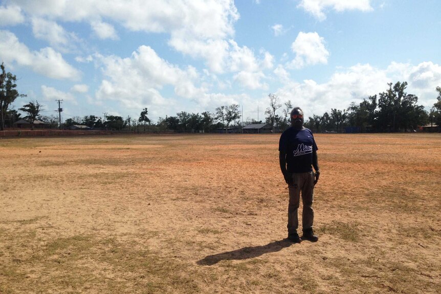 a man stands on empty footy oval