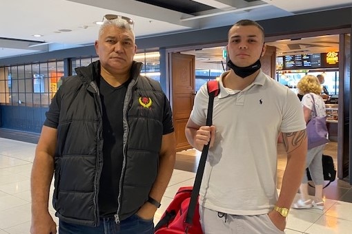 Father and son standing in an airport.
