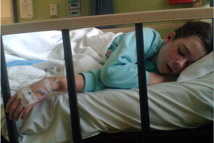 Lucy Alexander lying on hospital bed.