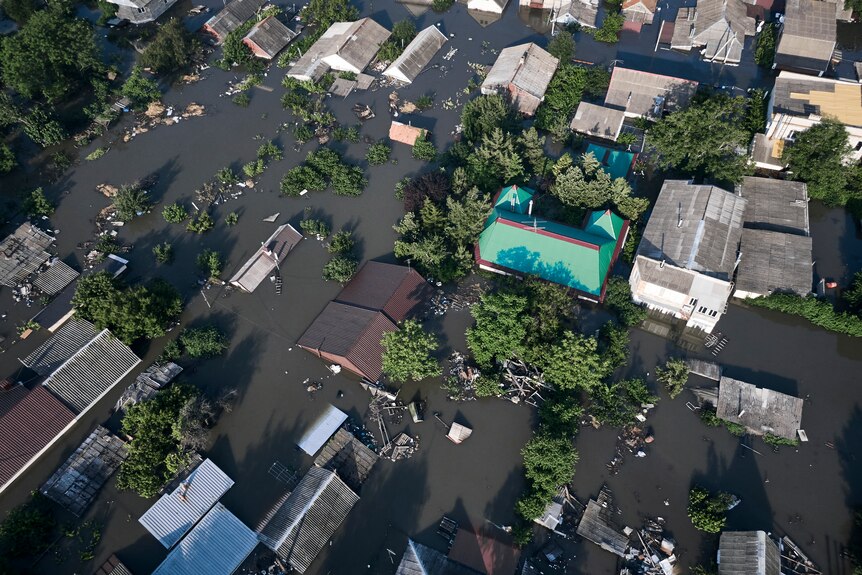 A view from above of water surrounding houses.