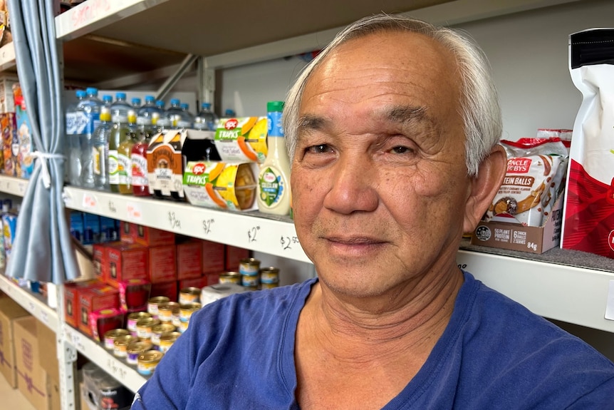 man in front of food shelf