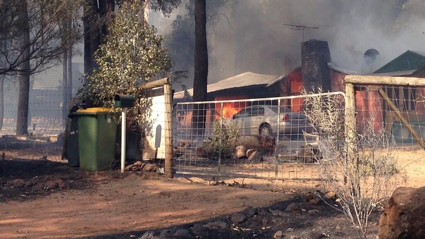 Fire burns through a home