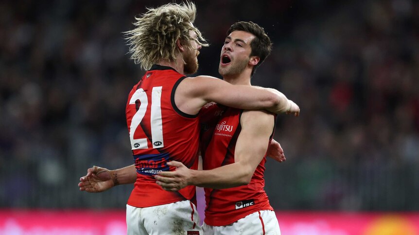 Kyle Langford's mouth is open as he engages in a big hug with Dyson Heppell.