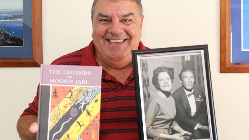 Glenn Miller holds a book called The Legends Of Moonie Jarl and a photo of his mother and uncle taken in the 1960s.