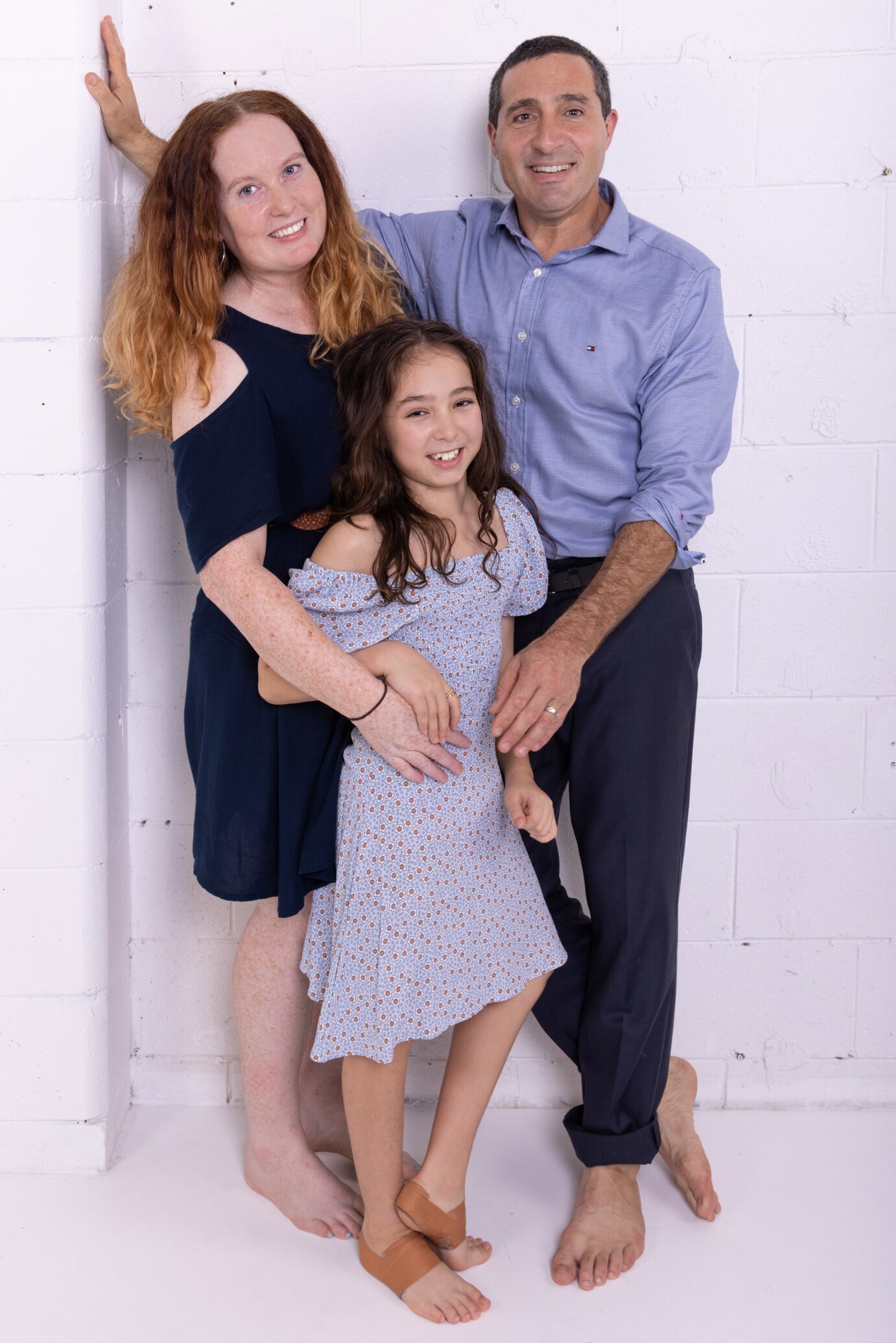 Una familia sonríe la una a la otra.