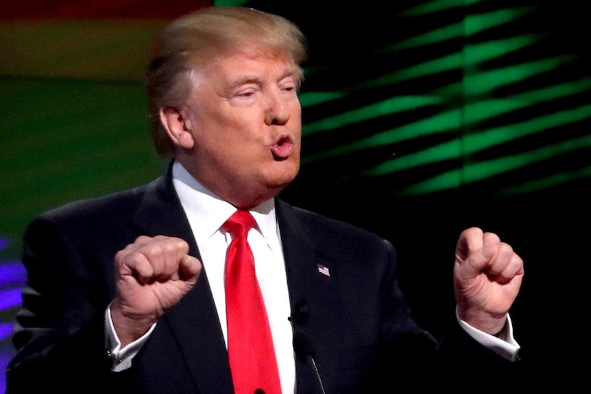 Close up photo of Donald Trump gesturing with both hands as he speaks at the Republican US presidential candidates debate.