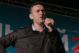Alexei Navalny speaks into the microphone on stage