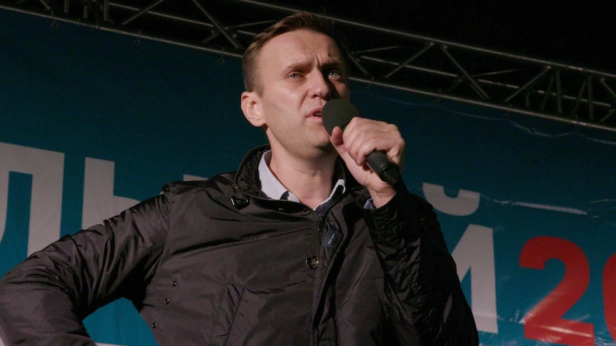 Alexei Navalny speaks into the microphone on stage