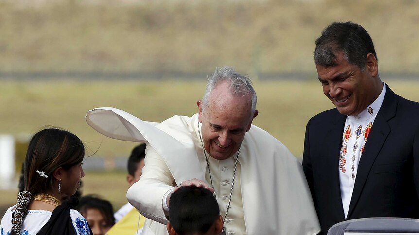 Pope Francis (L) is greeted by children as he is flanked by Ecuador's President Rafael Correa (R) after he landed in Quito, Ecuador, July 5, 2015.