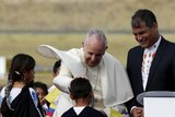 Pope Francis (L) is greeted by children as he is flanked by Ecuador's President Rafael Correa (R) after he landed in Quito, Ecuador, July 5, 2015.