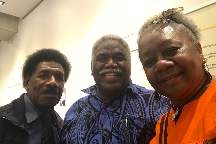 David Abel, a former Vanuatu MP with Indigenous Australian heritage, and Emelda Davis take a selfie with another man.