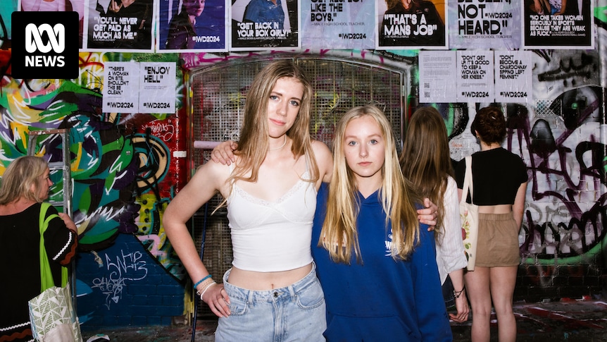 Teenager-Mädchen posten Kunstwerke in der Hosier Lane in Melbourne, die Sexismus und Frauenfeindlichkeit im Klassenzimmer dokumentieren