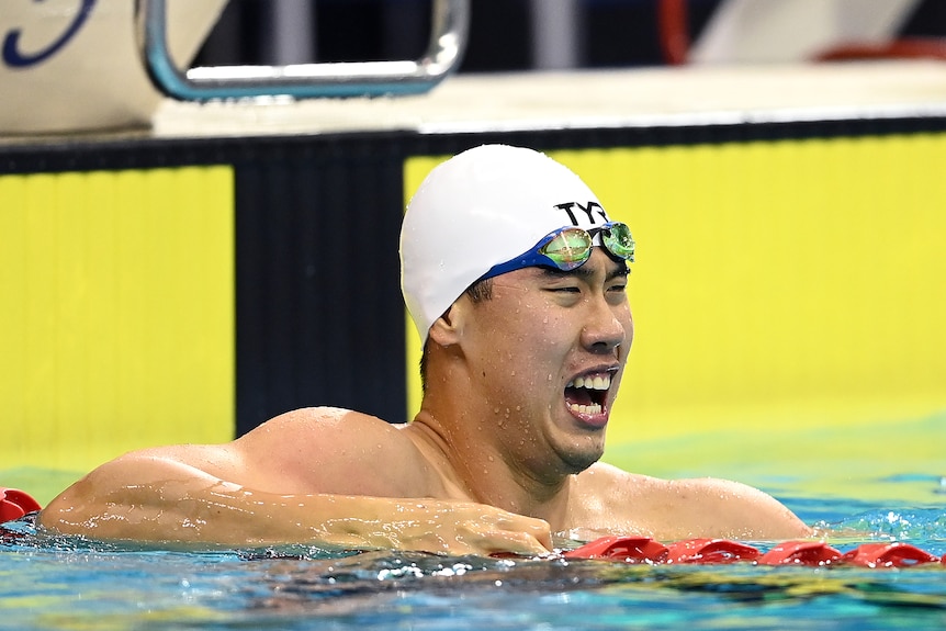 William Yang leans on the lane rope with his mouth wide open
