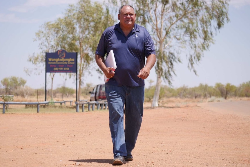 Lindsay Greatorex walking along dirt road with file under his arm