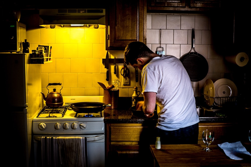 A man cooking in a small kitchen.
