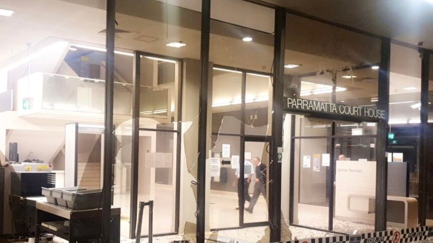 Smashed windows on a building with the words Parramatta Court House.