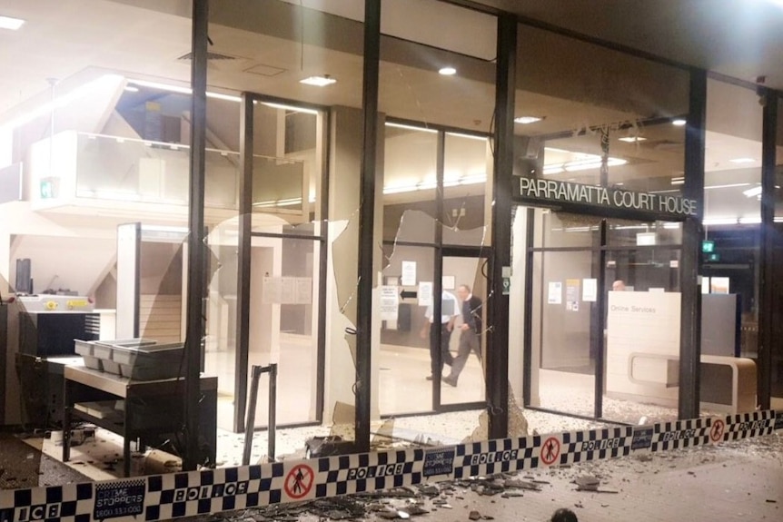 Smashed windows on a building with the words Parramatta Court House.