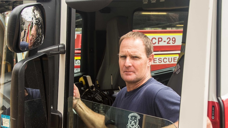 Firefighter inspects damaged truck hit by rocks and bricks