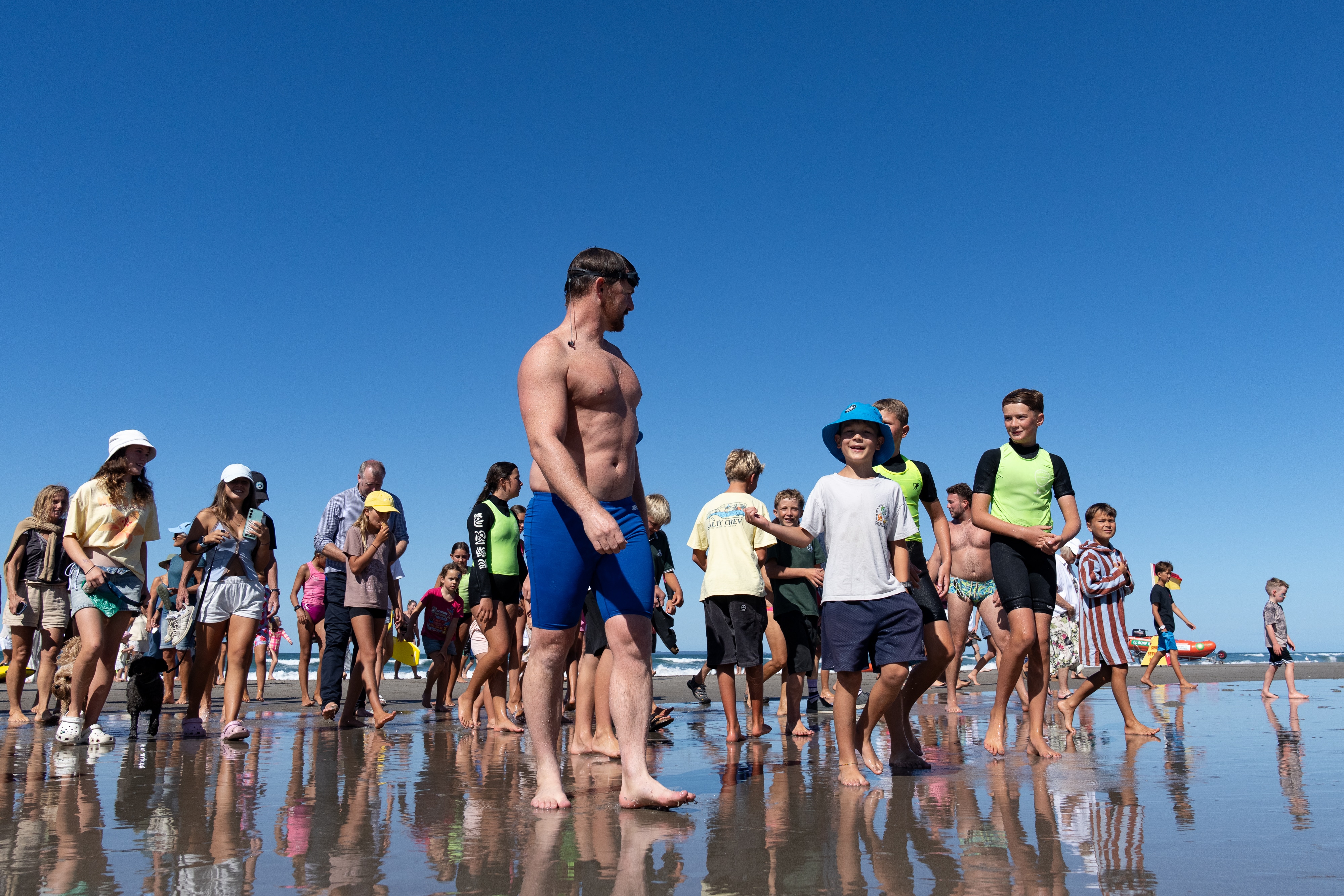 Jono Ridler leads kids out of the ocean