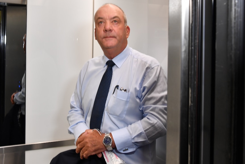 a man standing inside a lift