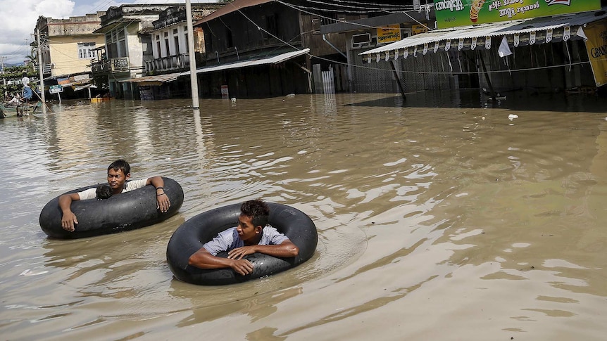 Men wade along a flooded street at Kalay township at Sagaing division