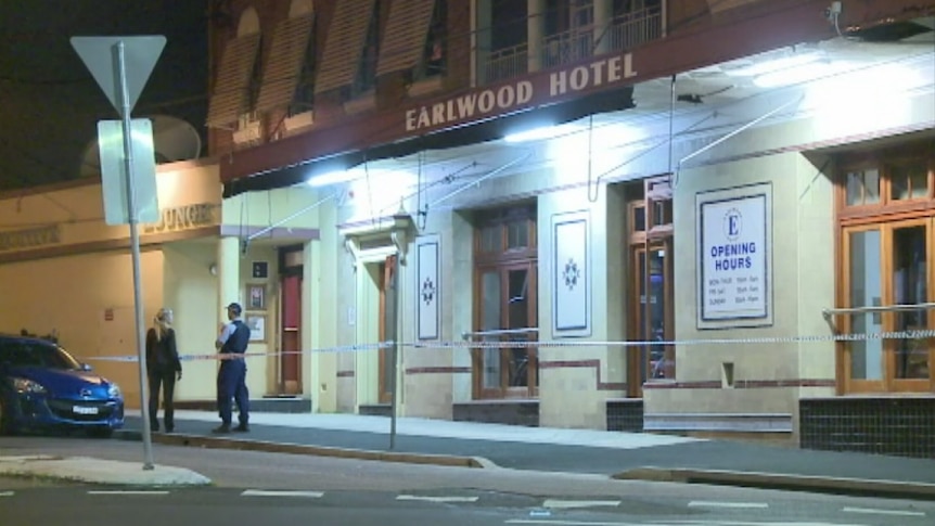 Police officers stand in front of Earlwood Hotel, with was robbed by a group of men armed with machetes and hatchets overnight.