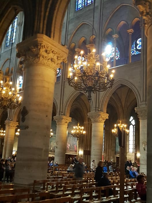 Worshippers, tourists and pews inside Notre Dame cathedral.