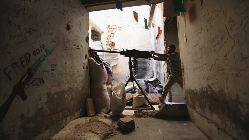 A Free Syrian Army fighter aims an anti-aircraft artillery weapon