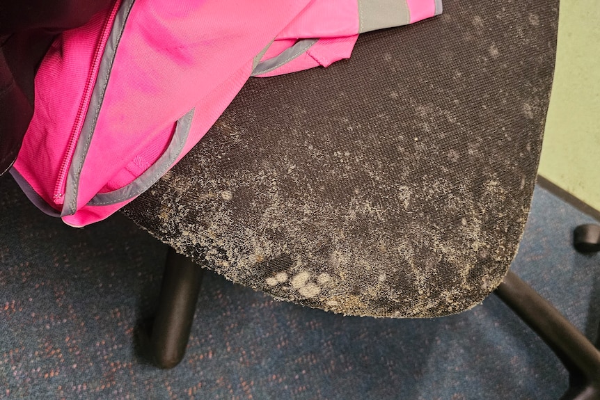 A swivel chair with mould growing on it.