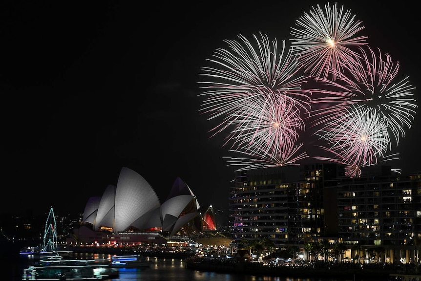 Fireworks explode over Sydney's Opera House and Harbour Bridge at night