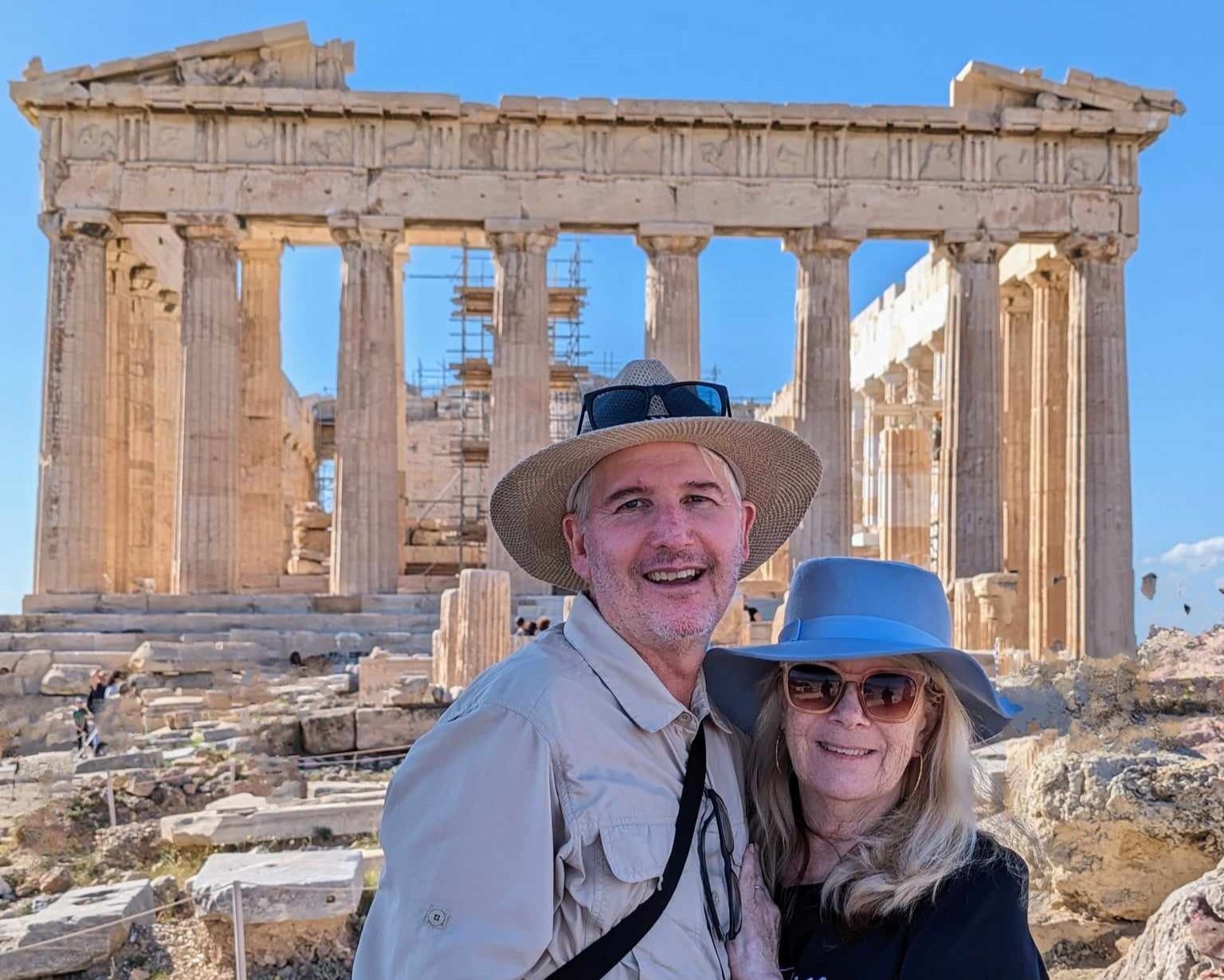 Couple smile with the ancient Acropolis behind them
