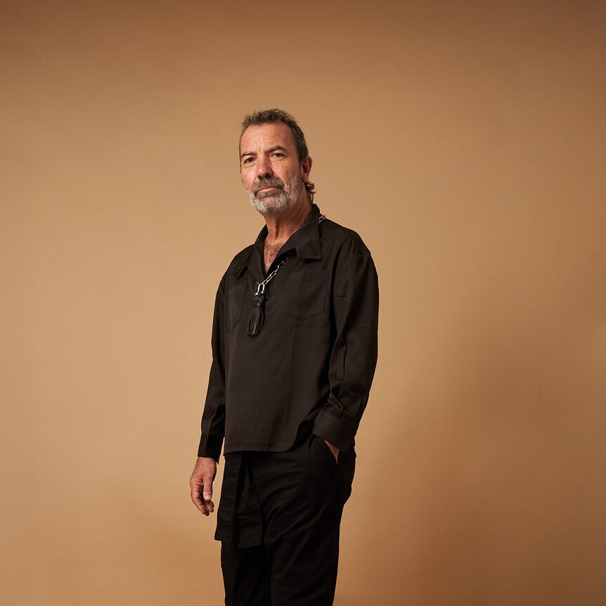 Full length portrait of Paul Mac in a casual black outfit