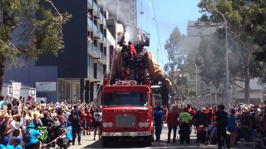 Giant diver marionette drinks from fire truck