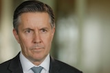 A close shot of Health Minister Mark Butler's face, looking serious.