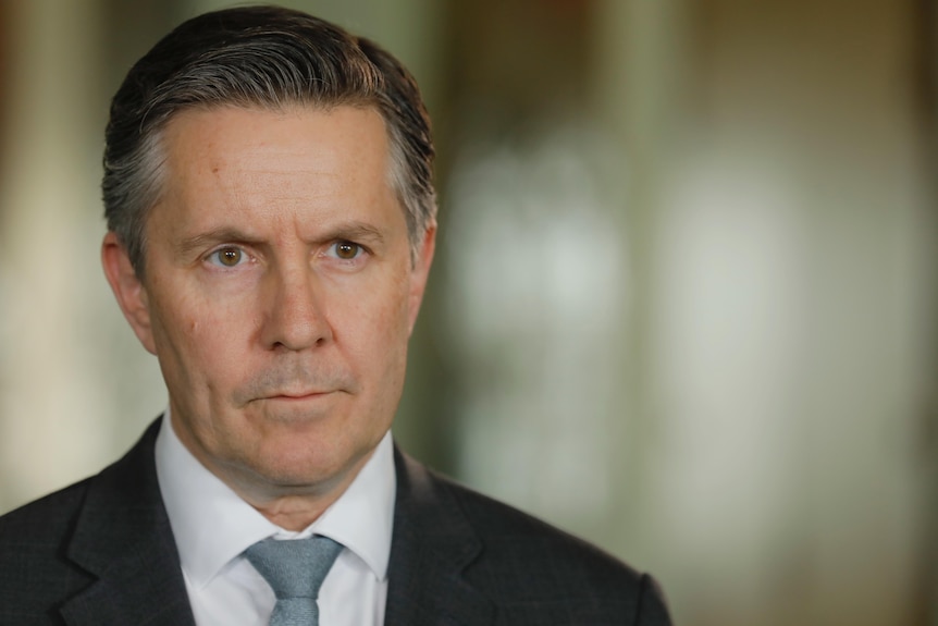 A close-up of Health Minister Mark Butler's face, looking serious.