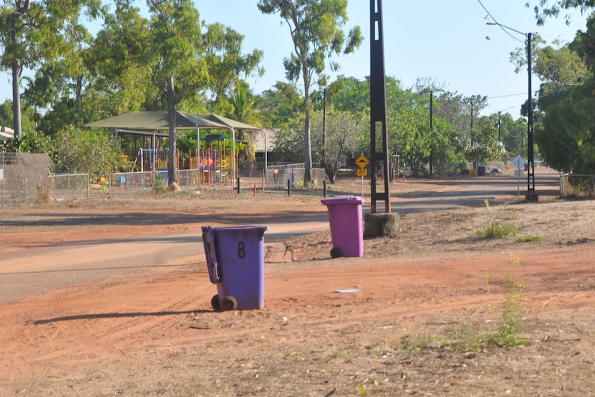 Bins in a remote Aboriginal community along a dirt street.