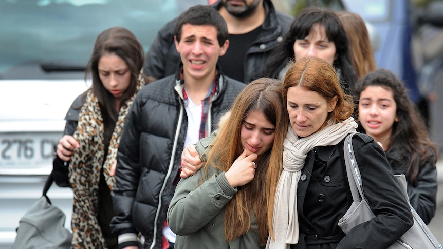 Young people walk away from shooting site