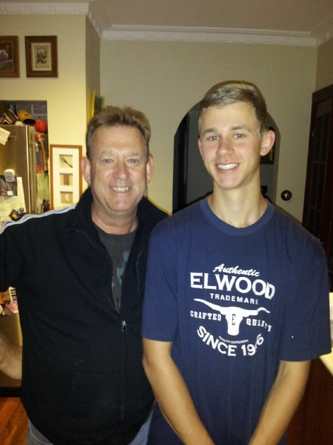 Murray Kinnane standing next to his son inside a house.