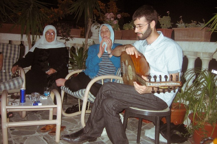 Amina claps as her son Majd plays the lute.