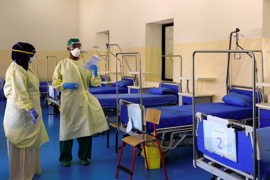 A Somali doctor and a nurse wear protective face masks as they prepare a ward for coronavirus disease.