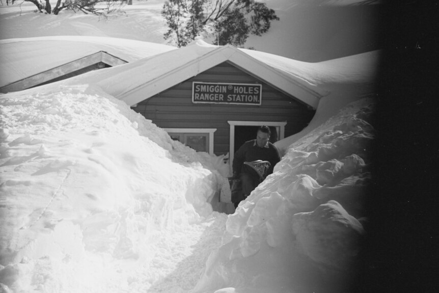 Black and white image of snowed in house.